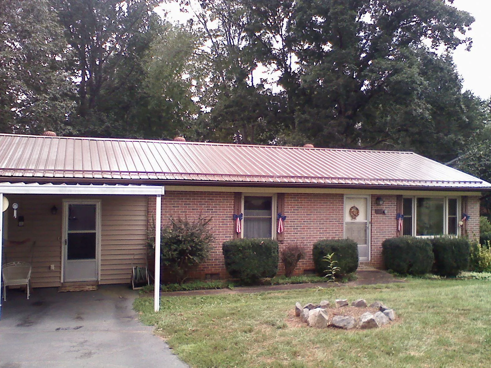 Bronze metal roof and carport on a brick ranch home — Roof Repair work by our crew in Forestville